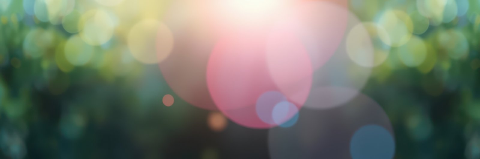 Colorful bokeh effect created by sunlight filtering through foliage during a sunny afternoon in the park